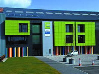 新建筑的表面覆盖着与众不同的明亮绿色太阳能采集钢板。