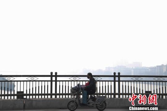 11月23日上午，柳州市区内出现雾霾天气，PM2.5浓度偏高使市区能见度低，不少外出的市民戴上了口罩。 黄威铭 摄