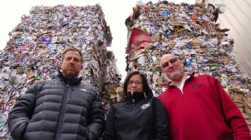 中国的“禁废令”让美国的垃圾供过于求。图为俄勒冈一个回收公司的员工站在堆积如山的垃圾前。（美国全国公共广播电台网站）